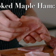 A hand holding thin slices of ham overtop a cutting board that has slices of pepperoni or some such meat also on it. The title says Smoked Maple Ham: 3.00